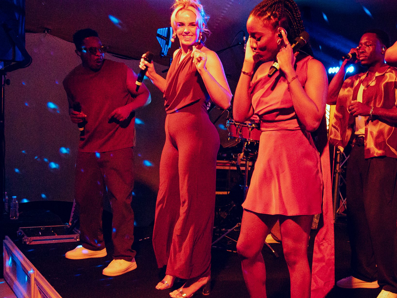 MYERA singers dancing on stage at a destination wedding